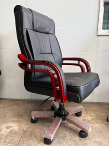 Black leather hydraulic barber chair with chrome accents and adjustable headrest
